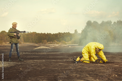 Slika na platnu Specialist in chemical protective suit localizing and pick up artillery grenade