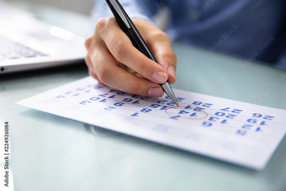 Businesswoman Marking Date On Calendar Businesswoman Marking Date On Calendar