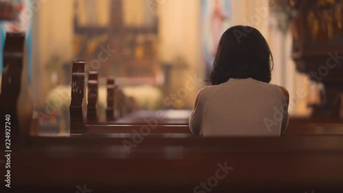 Back view of religious Christian woman sitting in the church while praying to GOD. Shot in 4k resolution