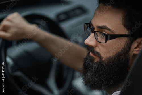 Close up portrait, serious man driving a car