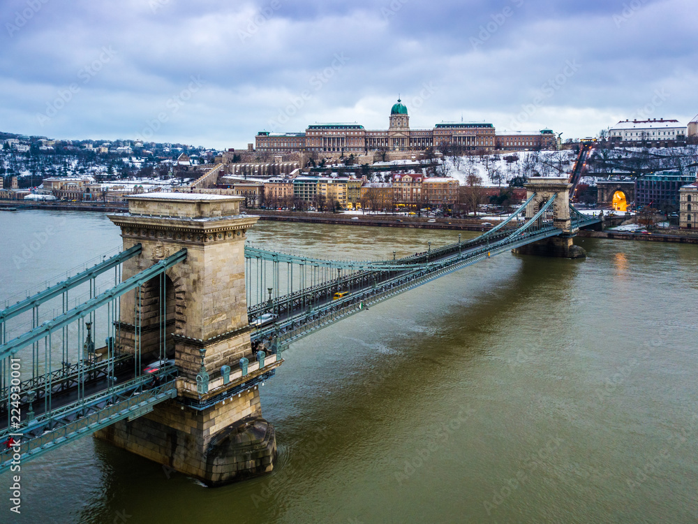 Budapest, Hungary - The beautiful Szechenyi Chain Bridge with Buda Castle Royal Palace at background on a cloudy winter day