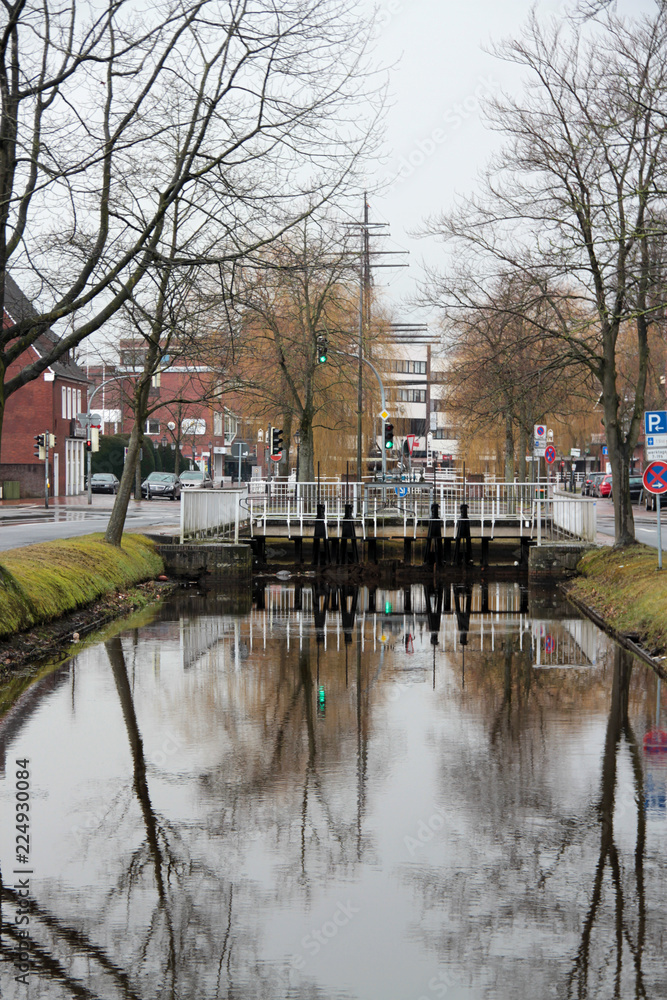 Fototapeta premium blick auf die brücke und wasser reflektionen im kanal der stadt papenburg deutschland fotografiert während einer sightseeing tour in papenburg deutschland