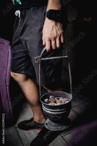 man holds in his hand coals for hookah photo