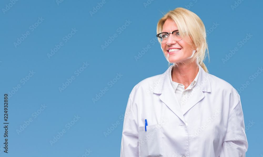 Middle age blonde therapist woman wearing white coat over isolated background looking away to side with smile on face, natural expression. Laughing confident. Middle age blonde therapist woman wearing white coat over isolated background looking away to side with smile on face, natural expression. Laughing confident.