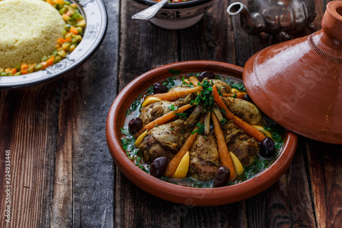 Morrocan dish chicken tajine on wooden table, copy space photo