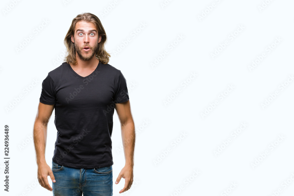 Obraz premium Young handsome man with long hair over isolated background afraid and shocked with surprise expression, fear and excited face.