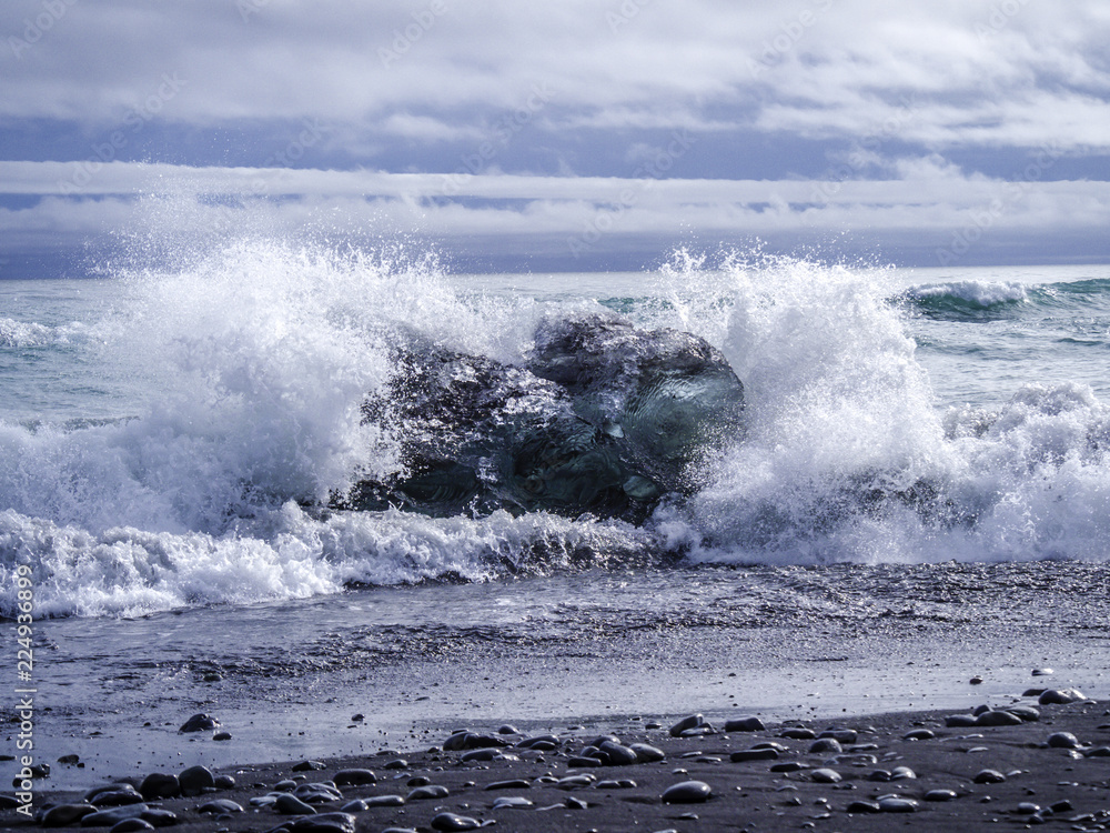 Ocean wave clashing at an iceberg on Diamond Beach in Iceland