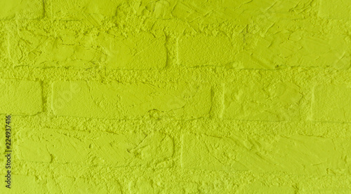 Modern neon yellow stone brick wall with big bricks close up background pattern