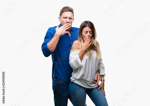 Young couple in love over isolated background bored yawning tired covering mouth with hand. Restless and sleepiness.