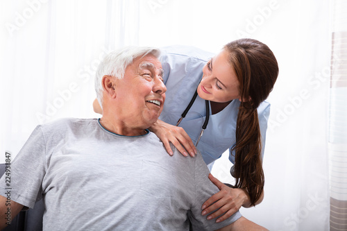Happy Female Nurse With Senior Man