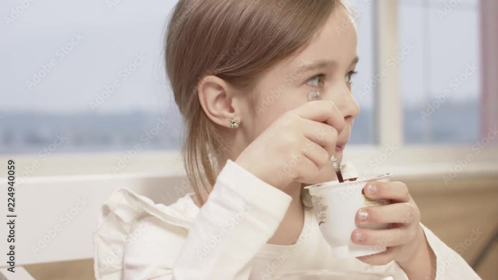 Little Girl Eats A Delicious Chocolate Mousse During A Family Dinner Little Girl Eats A Delicious Chocolate Mousse During A Family Dinner