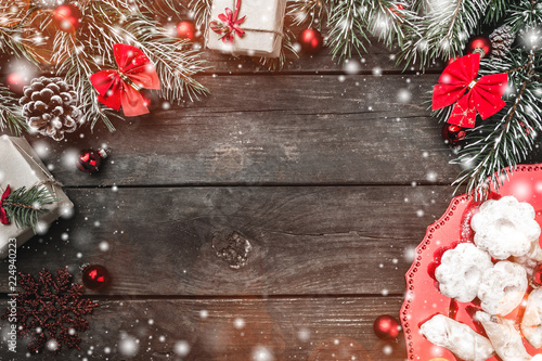 Wallpaper Mural Christmas theme with fir branches, red bows and globes, cones, present boxes, cookies and candies, on rustic dark wooden background viewed from above, top, in snow greeting card with space for text Torontodigital.ca