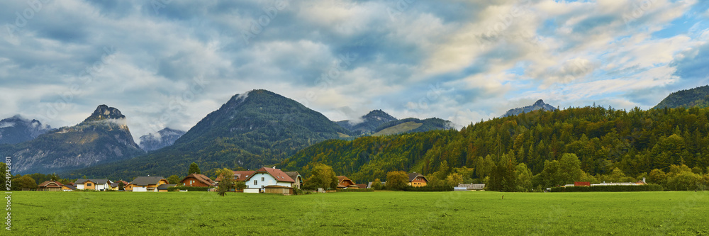 Beautiful landscape with lush green grass land and Alpine mountains near Wolfgangsee lake in Austria.
