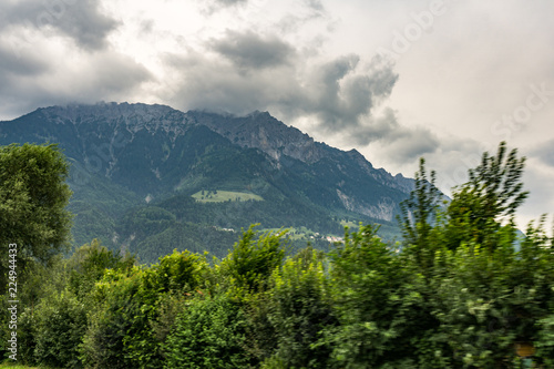 Alpen Berg mit Wolken. Bäume im Vordergrund