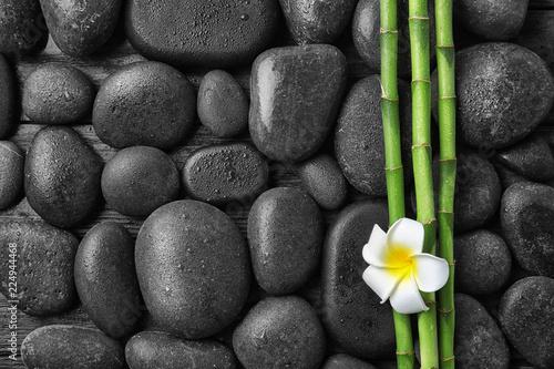 Flat lay composition with bamboo branches and spa stones as background. Space for text