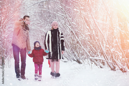 Young family with children are walking in the winter park. Winte