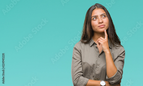 Young beautiful arab woman over isolated background with hand on chin thinking about question, pensive expression. Smiling with thoughtful face. Doubt concept. photo