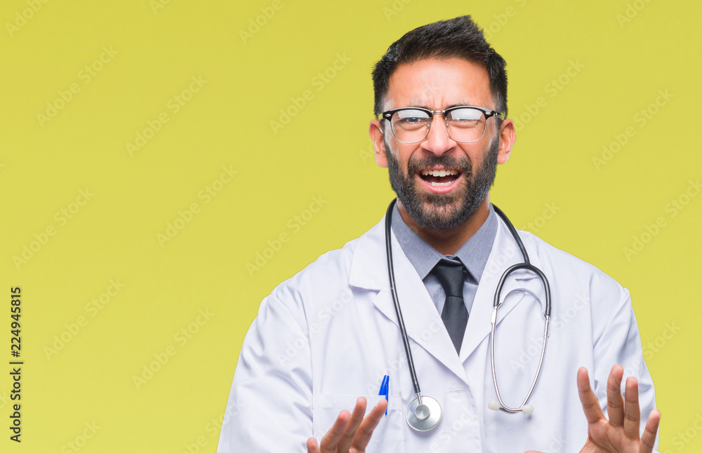 Adult hispanic doctor man over isolated background afraid and terrified with fear expression stop gesture with hands, shouting in shock. Panic concept. Adult hispanic doctor man over isolated background afraid and terrified with fear expression stop gesture with hands, shouting in shock. Panic concept.