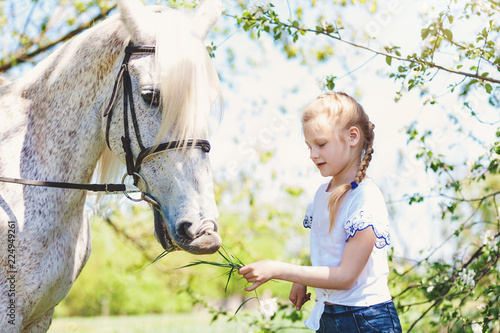 Photography Cute little girl whith white horse in blooming apple orchard