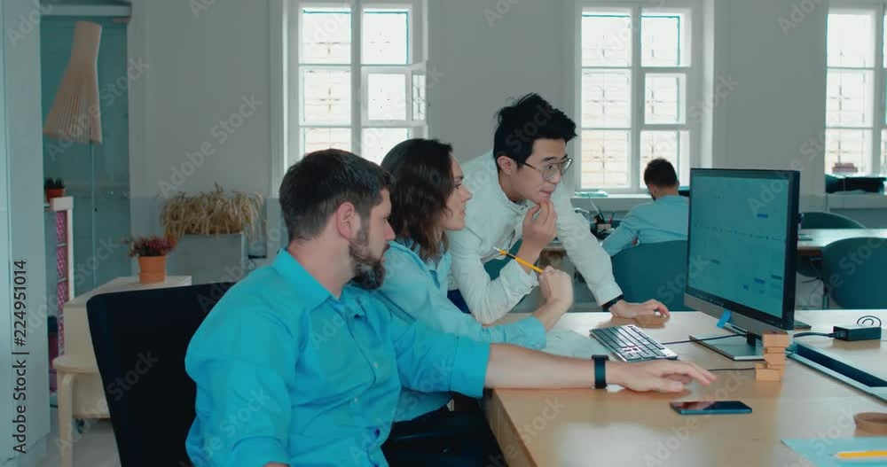 Office workers communicating together and discussing a project on a computer screen. 4K UHD 60 FPS SLOW MOTION Office workers communicating together and discussing a project on a computer screen. 4K UHD 60 FPS SLOW MOTION
