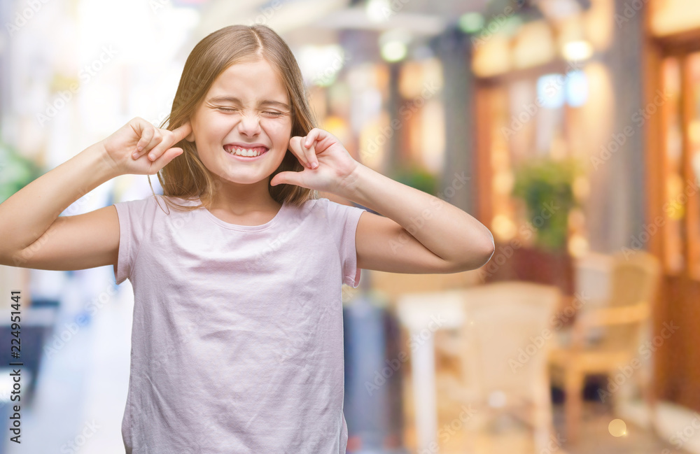 Young beautiful girl over isolated background covering ears with fingers with annoyed expression for the noise of loud music. Deaf concept.