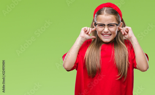 Young beautiful girl wearing glasses over isolated background covering ears with fingers with annoyed expression for the noise of loud music. Deaf concept.