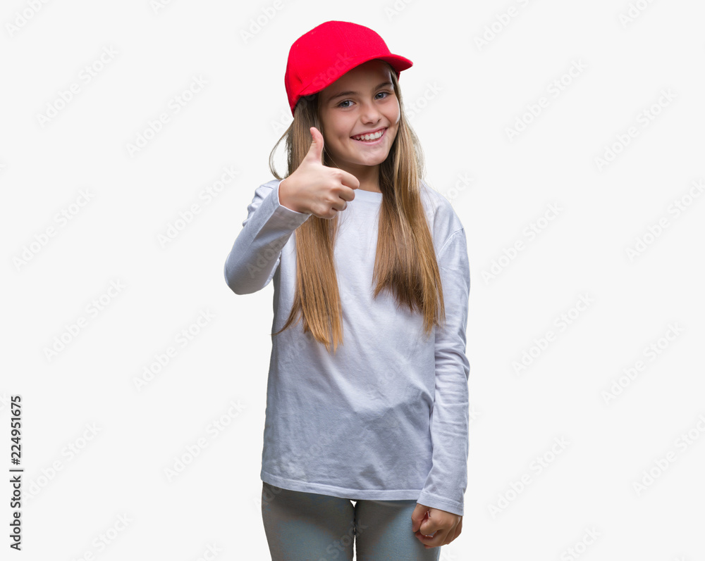 Young beautiful girl wearing red cap isolated background doing happy thumbs up gesture with hand. Approving expression looking at the camera with showing success. Young beautiful girl wearing red cap isolated background doing happy thumbs up gesture with hand. Approving expression looking at the camera with showing success.