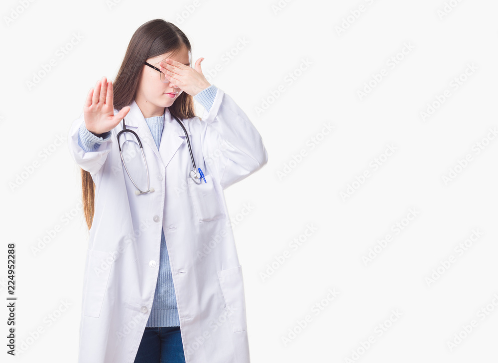 Young Chinese doctor woman over isolated background covering eyes with hands and doing stop gesture with sad and fear expression. Embarrassed and negative concept. Young Chinese doctor woman over isolated background covering eyes with hands and doing stop gesture with sad and fear expression. Embarrassed and negative concept.