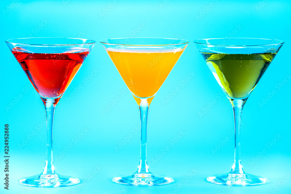 Three wine glasses with drinks on a blue background Three wine glasses with drinks on a blue background