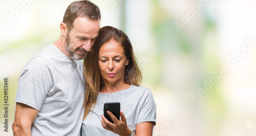 Middle age hispanic couple texting message on smartphone ver isolated background with a confident expression on smart face thinking serious