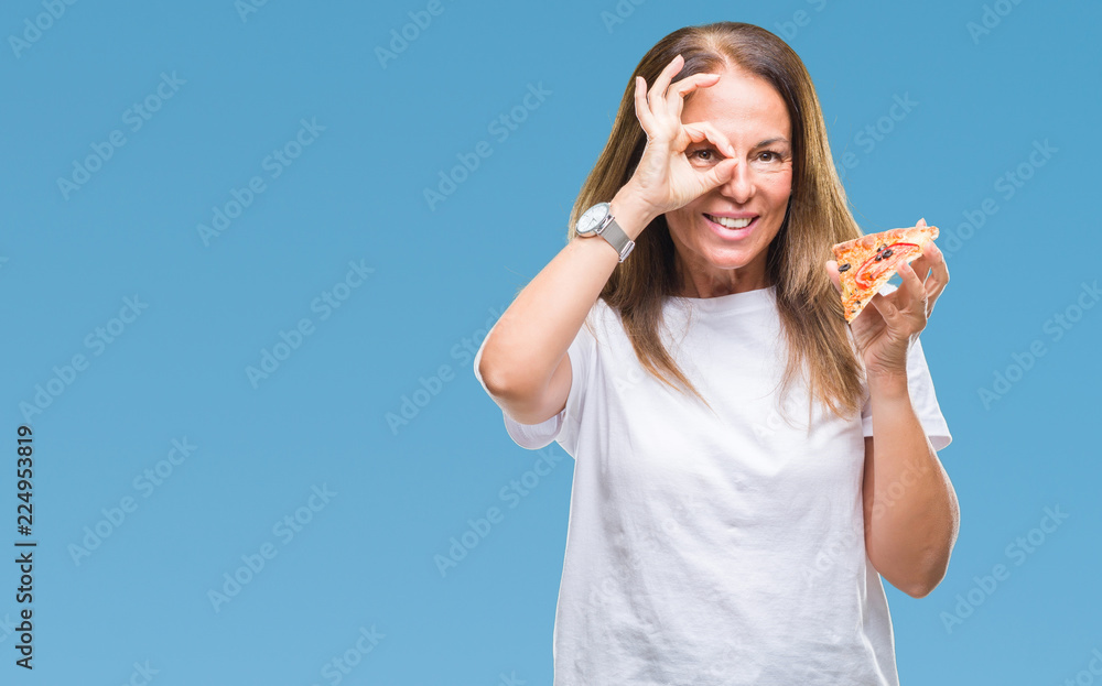 Middle age hispanic woman eating pizza slice over isolated background with happy face smiling doing ok sign with hand on eye looking through fingers Middle age hispanic woman eating pizza slice over isolated background with happy face smiling doing ok sign with hand on eye looking through fingers
