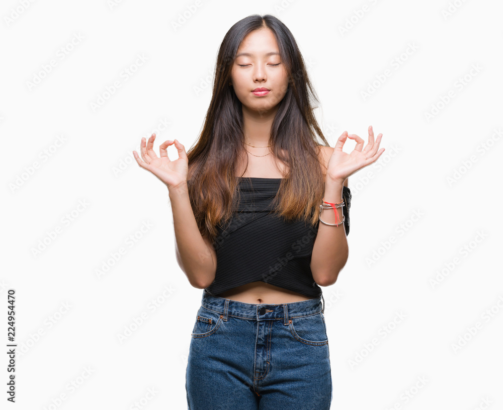 Young asian woman over isolated background relax and smiling with eyes closed doing meditation gesture with fingers. Yoga concept. Young asian woman over isolated background relax and smiling with eyes closed doing meditation gesture with fingers. Yoga concept.