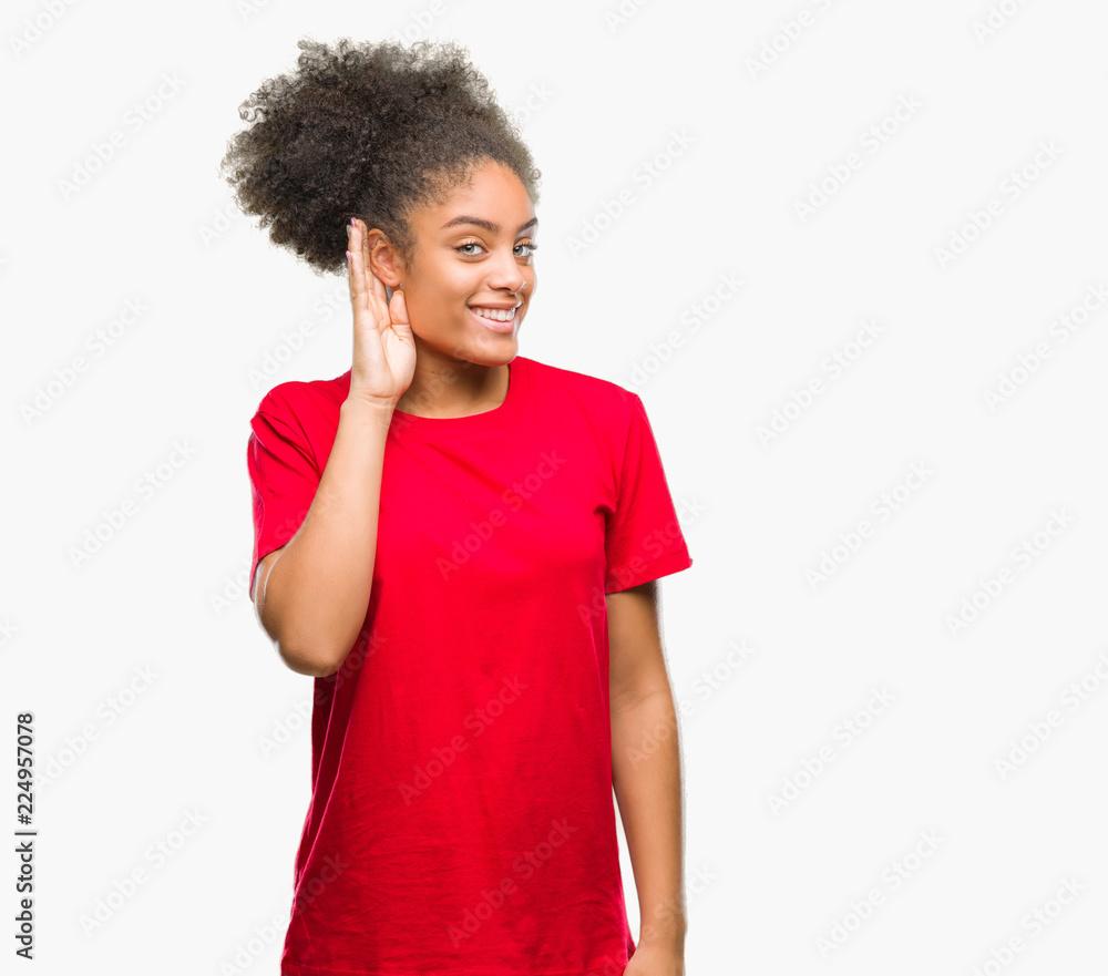 Young afro american woman over isolated background smiling with hand over ear listening an hearing to rumor or gossip. Deafness concept. Young afro american woman over isolated background smiling with hand over ear listening an hearing to rumor or gossip. Deafness concept.