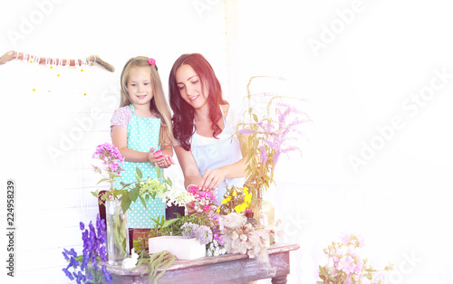 A young girl with a daughter is picking up a bouquet. A young mo