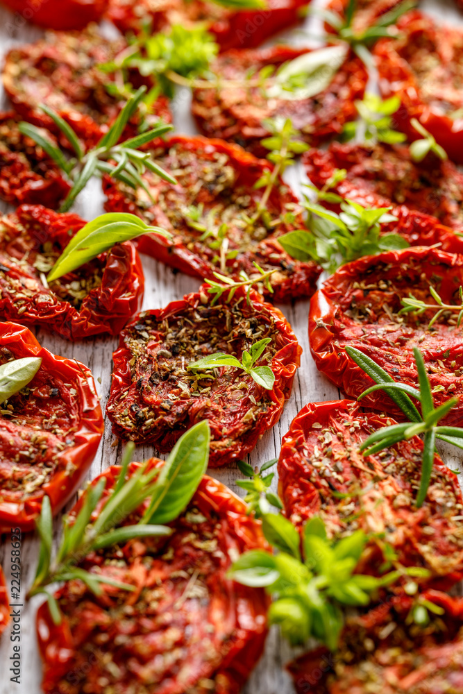 Dried tomatoes, dried tomato halves with the addition of aromatic herbs, close-up