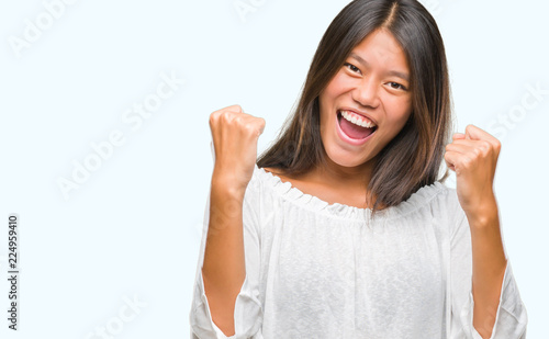 Wallpaper Mural Young asian woman over isolated background very happy and excited doing winner gesture with arms raised, smiling and screaming for success. Celebration concept. Torontodigital.ca