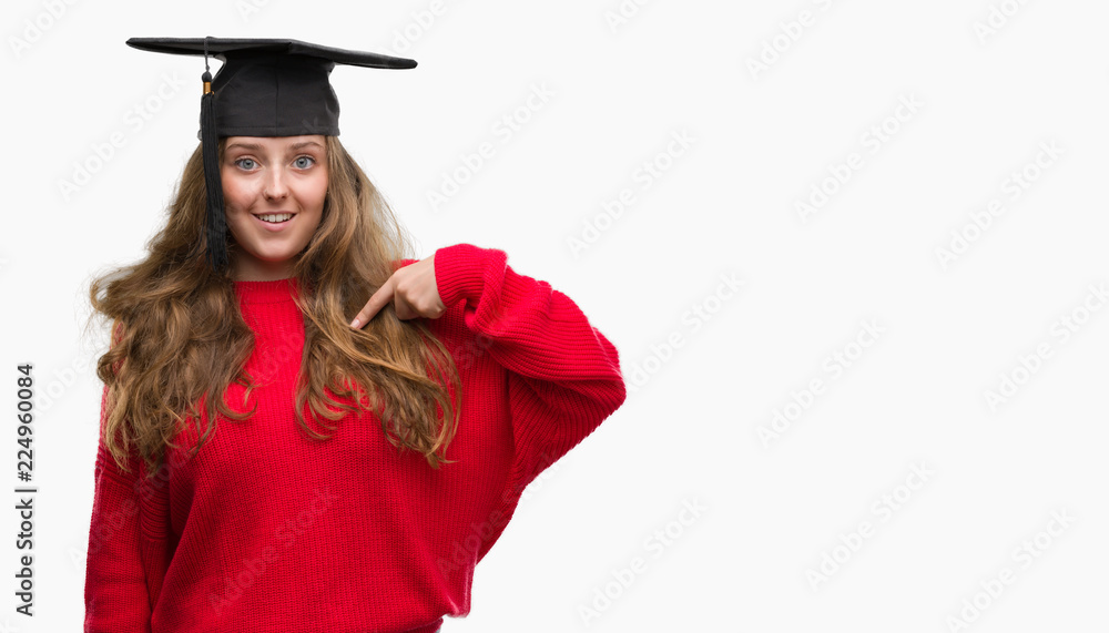 Young blonde woman wearing graduation cap with surprise face pointing finger to himself Young blonde woman wearing graduation cap with surprise face pointing finger to himself