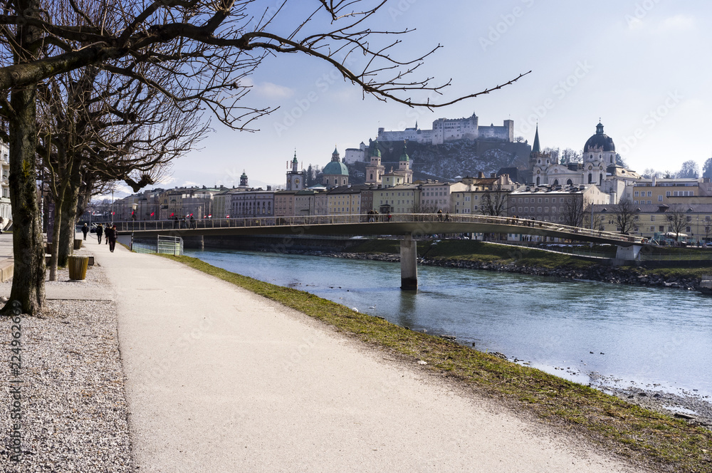Salzburg from the banks of the Salzach River on a clear sunny day with snow