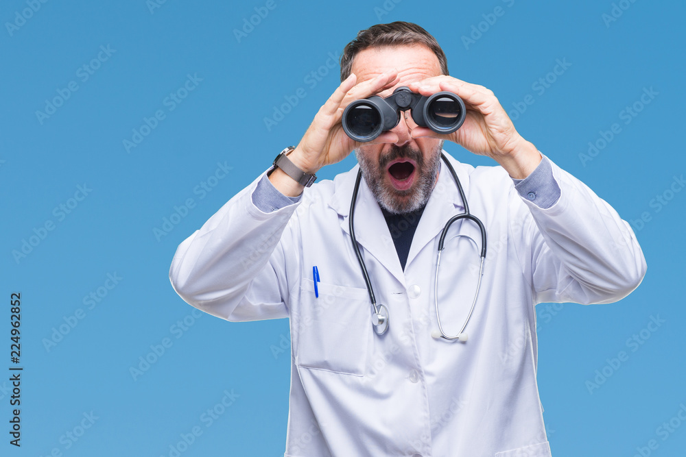 Middle age senior hoary doctor man looking through binoculars isolated background scared in shock with a surprise face, afraid and excited with fear expression Middle age senior hoary doctor man looking through binoculars isolated background scared in shock with a surprise face, afraid and excited with fear expression