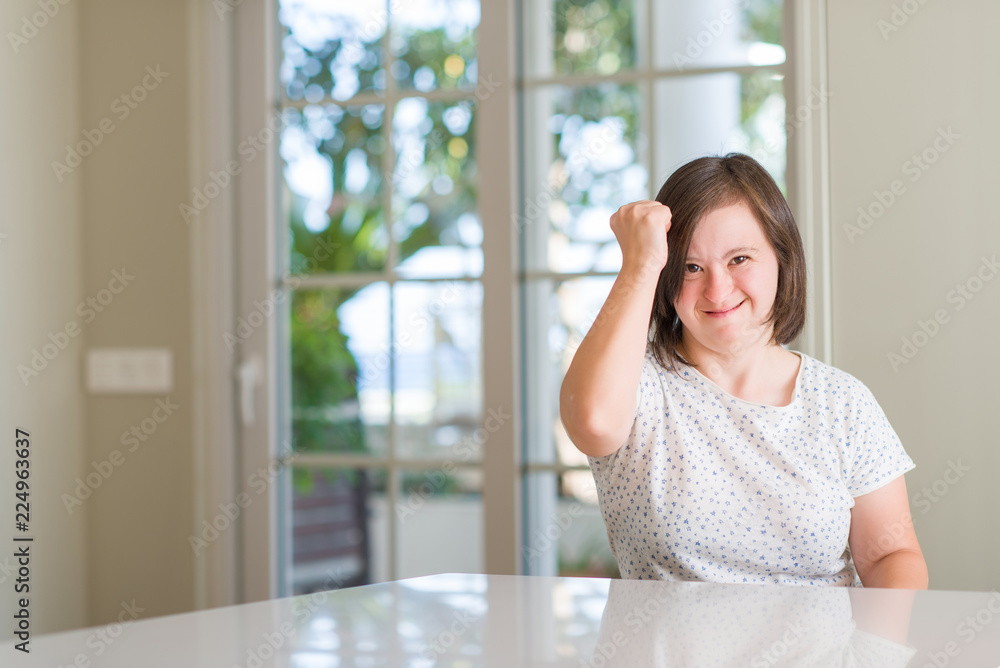 Down syndrome woman at home annoyed and frustrated shouting with anger, crazy and yelling with raised hand, anger concept