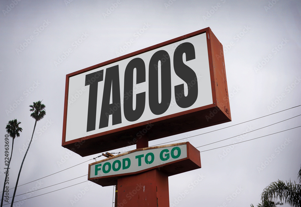 aged and worn tacos sign on overcast day aged and worn tacos sign on overcast day