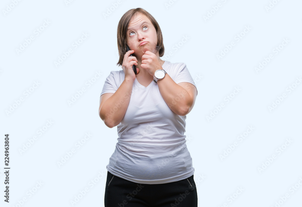 Young adult woman with down syndrome taking using smartphone over isolated background serious face thinking about question, very confused idea Young adult woman with down syndrome taking using smartphone over isolated background serious face thinking about question, very confused idea