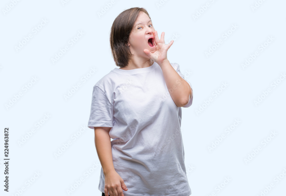 Young adult woman with down syndrome over isolated background shouting and screaming loud to side with hand on mouth. Communication concept. Young adult woman with down syndrome over isolated background shouting and screaming loud to side with hand on mouth. Communication concept.