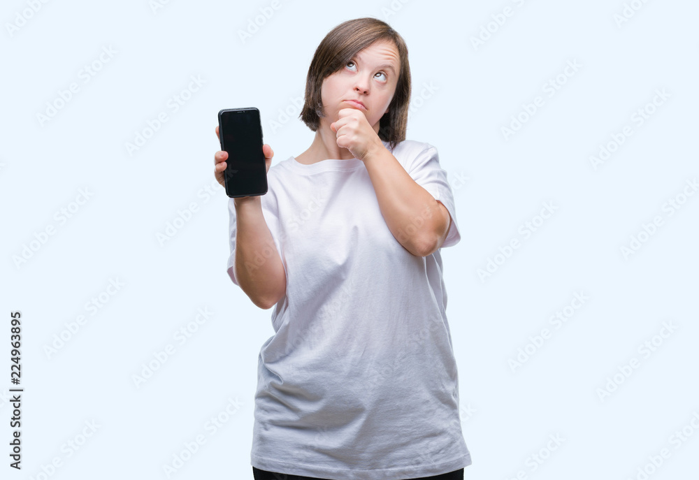 Young adult woman with down syndrome showing smartphone screen over isolated background serious face thinking about question, very confused idea Young adult woman with down syndrome showing smartphone screen over isolated background serious face thinking about question, very confused idea