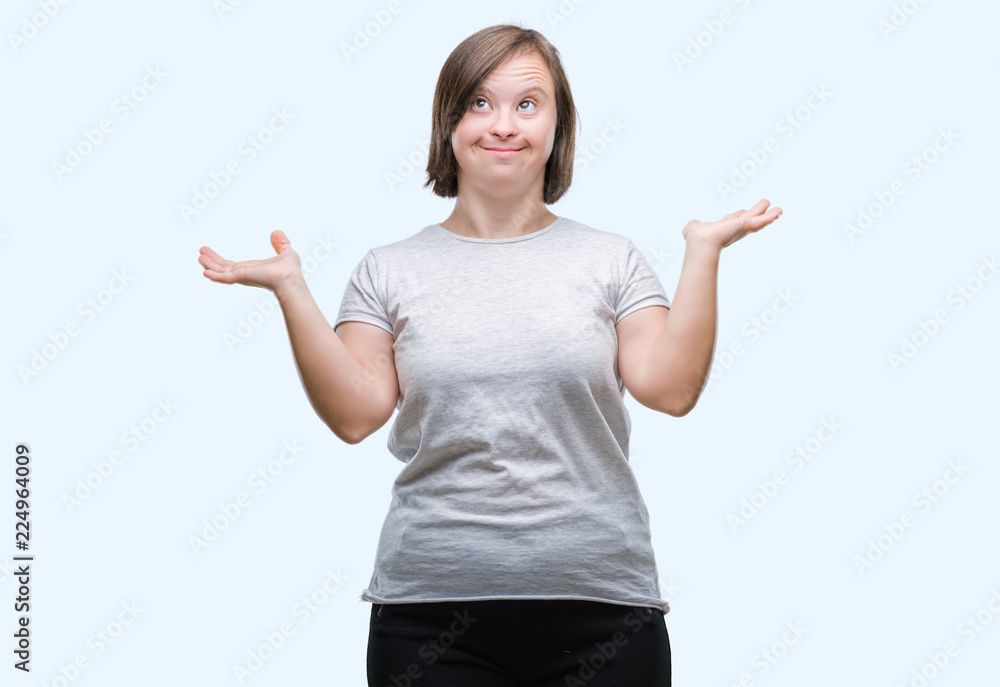 Young adult woman with down syndrome over isolated background clueless and confused expression with arms and hands raised. Doubt concept. Young adult woman with down syndrome over isolated background clueless and confused expression with arms and hands raised. Doubt concept.