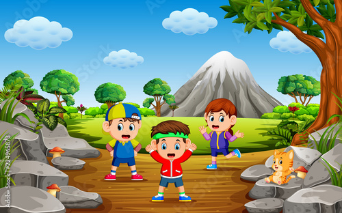the children do sport in the forest near the rock mountain with a lot of trees
