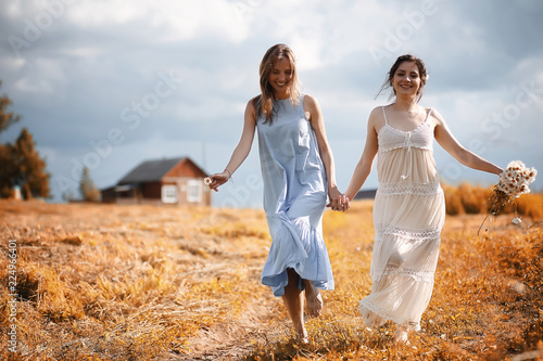 Two girls in dresses in autumn field