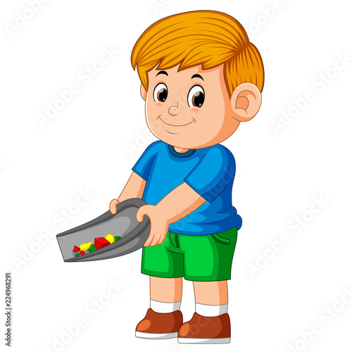 the boy using the blue cloth and standing to clean up the trash in the shade
