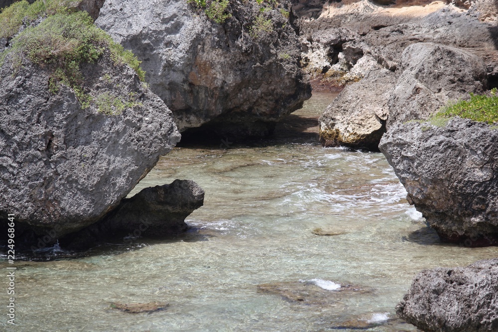 Fototapeta premium Big rocks at a small enclosure where water flows in a tropical beach