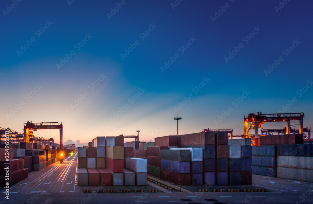 Fotografie When the container terminal at dusk, work cranes and forklift.